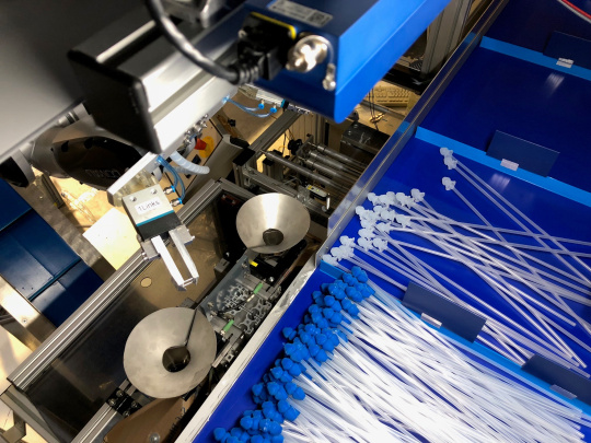 Un robot trie des cathéters avec des embouts bleus et blancs à l'aide d'une caméra 3D Ensenso.