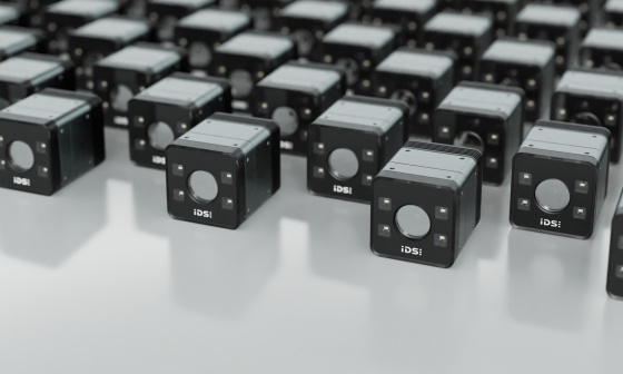 Des caméras industrielles de forme cubique sont alignées sur une surface réfléchissante