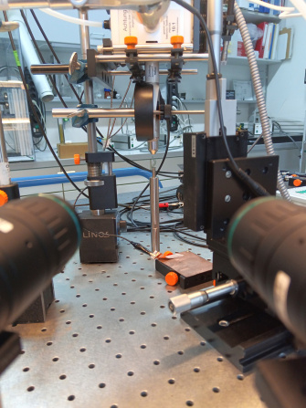 Montage expérimental sur une table optique équipé de deux caméras latérales et d'une source de plasma