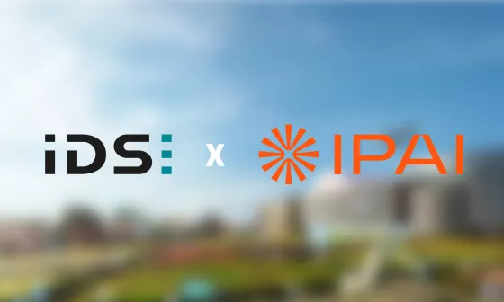 Die Logos von IDS und IPAI stehen nebeneinander. Im Hintergrund ist die Vision des Campus des IPAIs zu sehen.