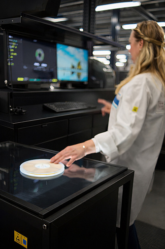 Une femme scanne une étiquette ronde à l'aide du Vision AI Label Reader.