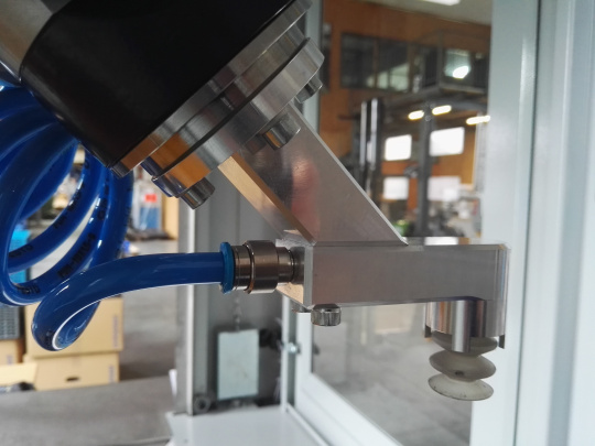 Bras de robot dans une cellule robotisée avec câble bleu
