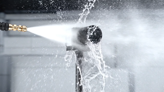 Une caméra industrielle est soumise à un puissant jet d’eau à courte distance.