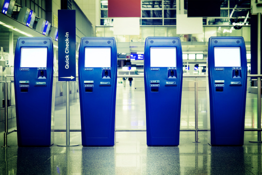 Quatre terminaux d'enregistrement rapide dans un hall d'aéroport