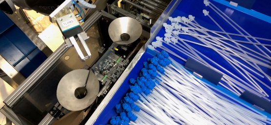Un robot trie des cathéters avec des embouts bleus et blancs à l'aide d'une caméra 3D Ensenso.