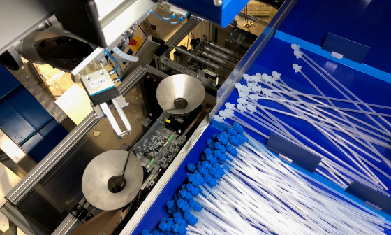 Un robot trie des cathéters avec des embouts bleus et blancs à l'aide d'une caméra 3D Ensenso.