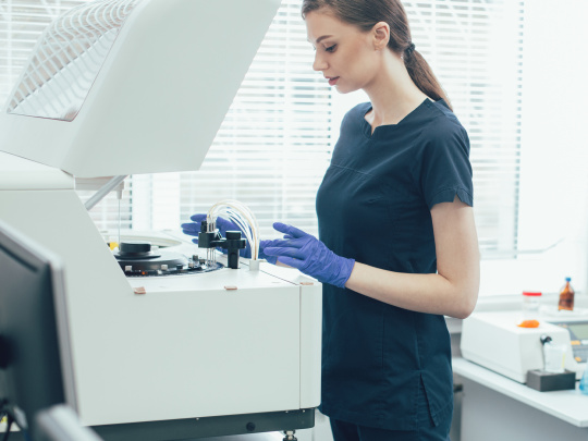 Une femme dans un laboratoire met en service un appareil de diagnostic à l'aide d'une caméra IDS uEye+ XLE.