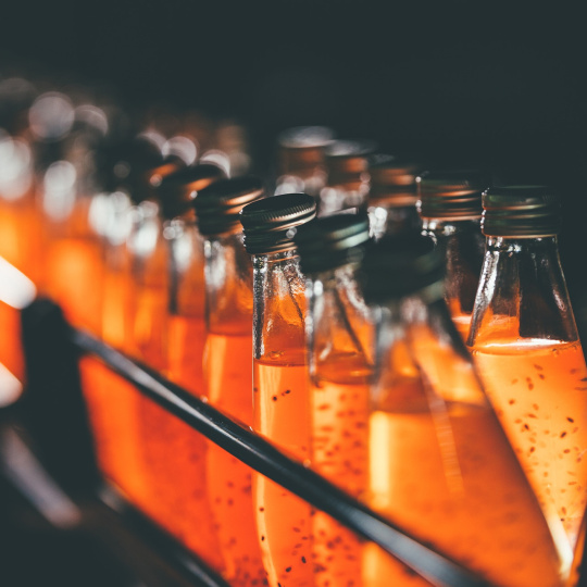 Bouteilles en verre sur une étagère contenant un liquide orange.