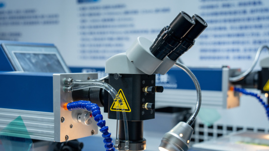 Microscope binoculaire avec tuyaux et lampe dans un laboratoire.