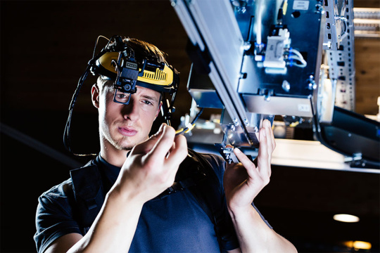 Un homme équipé d'une caméra sur casque effectue un montage sur une machine