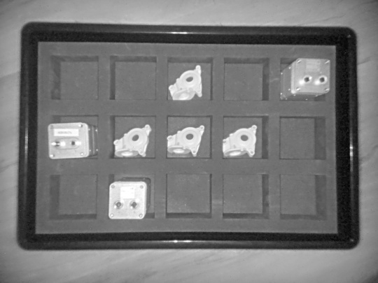 Image d'intensité en gris de la caméra 3D Nion montrant différents objets dans une boîte avec des compartiments de tri, vue de dessus.