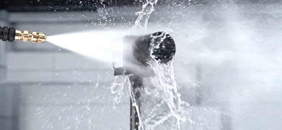 Une caméra industrielle est aspergée d'un puissant jet d'eau à courte distance.