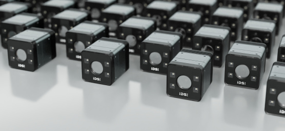 Des caméras industrielles de forme cubique sont alignées sur une surface réfléchissante
