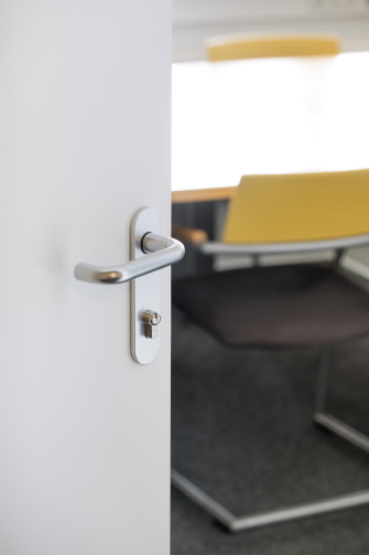 Porte ouverte avec une poignée de porte moderne et un dispositif d'accès à l'intérieur.