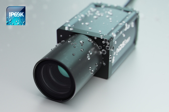 Caméra IDS NXT intelligente avec objectif et gouttes d'eau sur le boîtier et icône IP69K