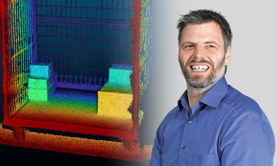 Le chef de produit rayonnant de joie tient la caméra Nion 3D dans sa main, avec un nuage de points en arrière-plan.