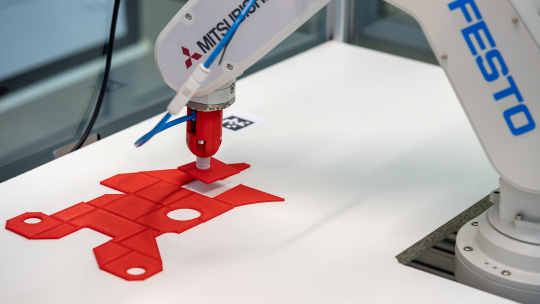 Le bras du robot place le composant à la position spécifiée.