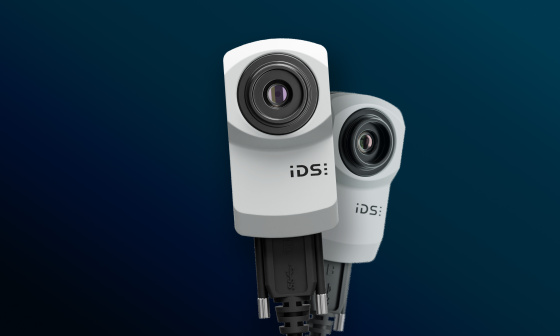 Deux caméras industrielles IDS uEye XC sur fond bleu.