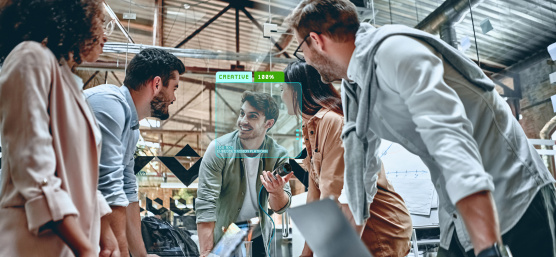 Collaboration : 5 personnes sont réunies autour d'un bureau avec des ordinateurs portables.