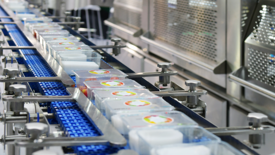 Barquettes alimentaires emballées sur une ligne convoyeur automatisée