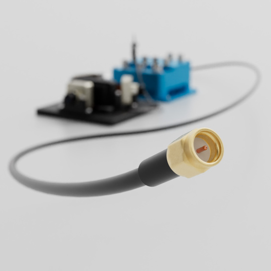 Connecteur coaxial doré avec câble devant un circuit imprimé flou